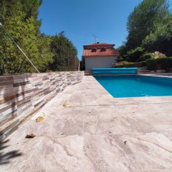 Zona de piscina reformada con suelo y paredes de baldosas cerámicas grandes